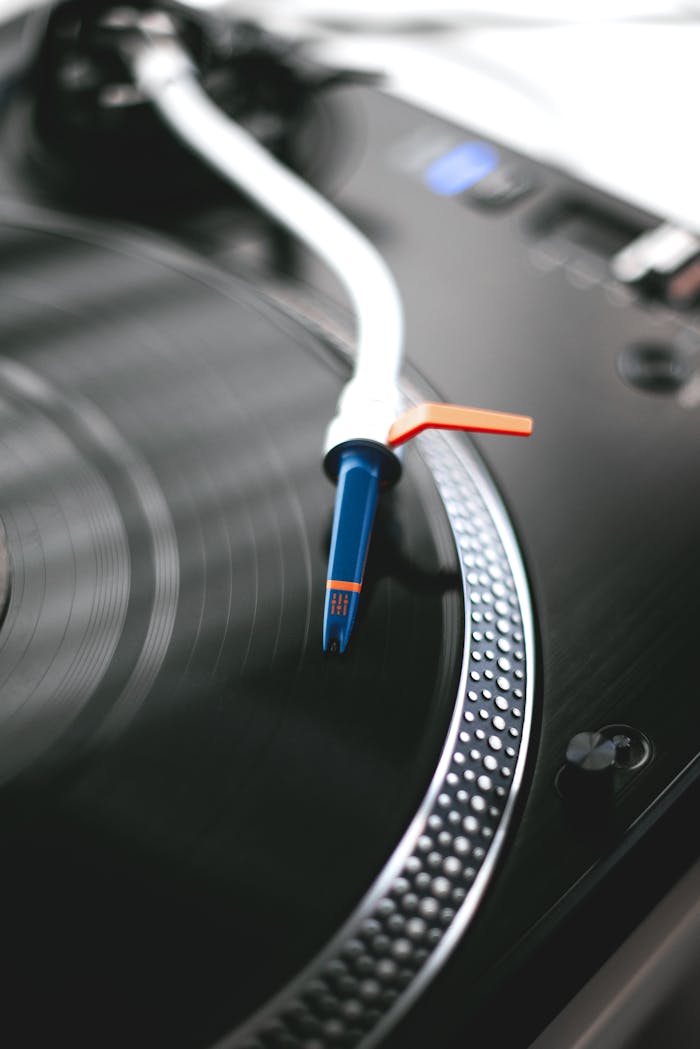 the-story Detailed view of turntable needle touching a spinning vinyl record, creating a retro vibe.